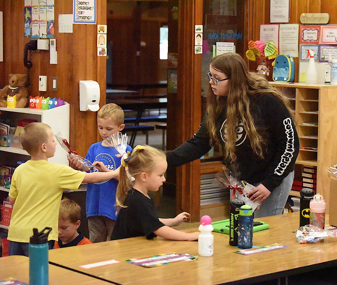 Libby High School student Ashley Cockerham hands a goodie bag to an elementary school student Friday, Nov. 3, during Red Ribbon Week. (Scott Shindledecker/The Western News)