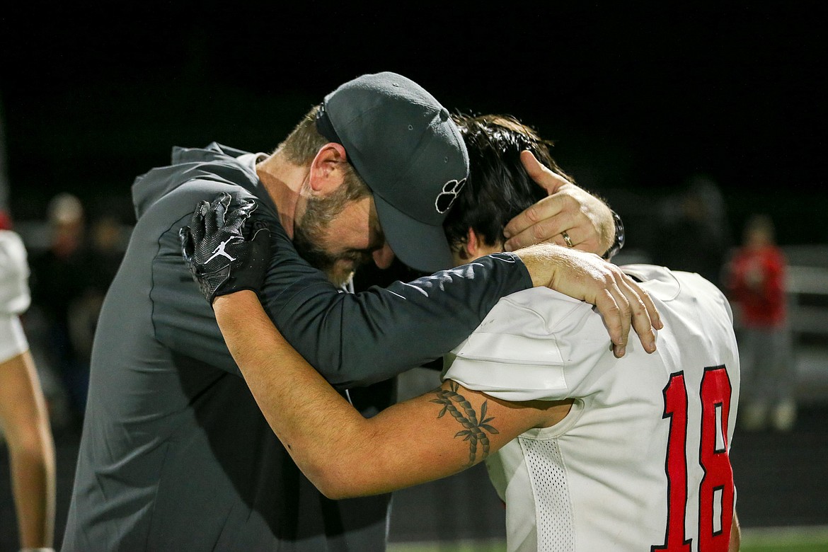 Sandpoint head coach Ryan Knowles hugs senior Kody Brewster after Friday night's 44-23 loss to Pocatello.