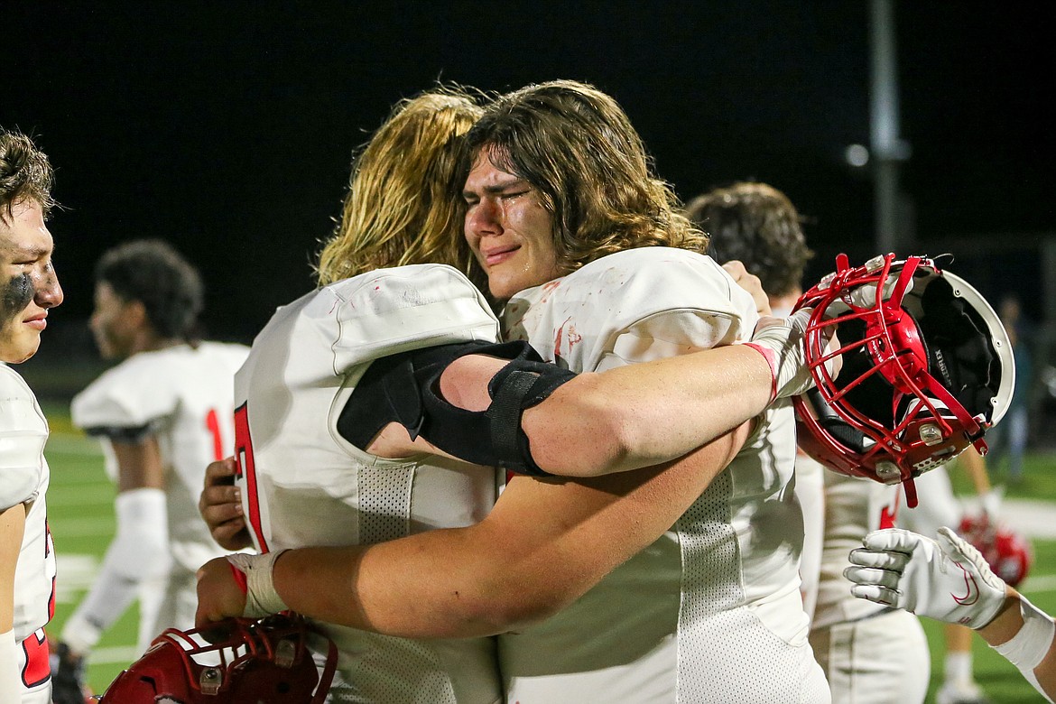 Sandpoint senior Levi Dorrel and junior Gavin Walters support each other with a hug after Friday night's loss to Pocatello.