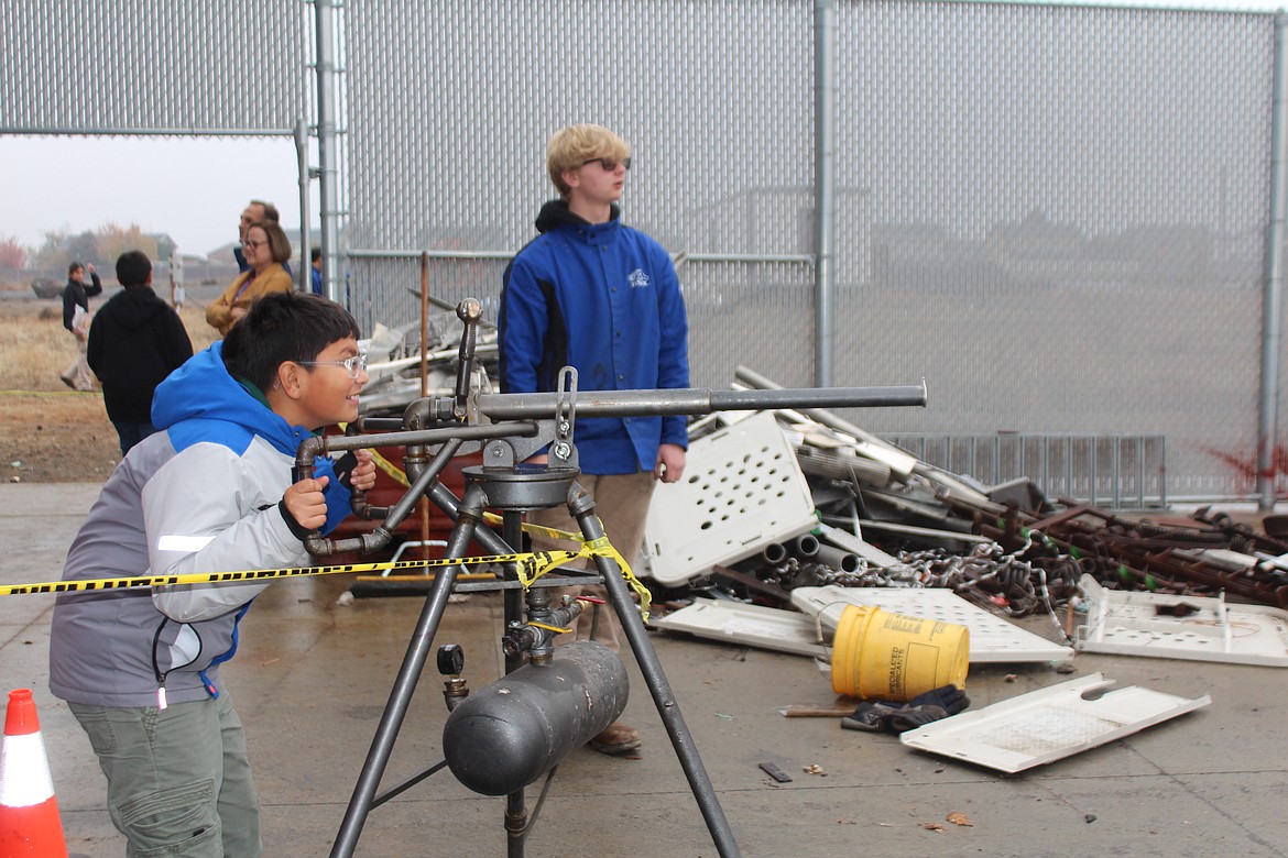 A fifth grader lines up his shot before pulling the lever on the potato launcher.