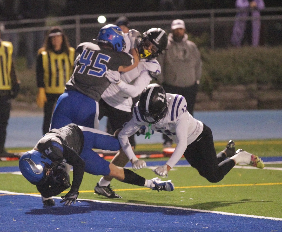 MARK NELKE/Press
Coeur d'Alene senior Joe Hagel plunges into the end zone on a 1-yard touchdown reception from Caden Symons in the second quarter as Rocky Mountain's Hayden Thompson (11) defends in a state 5A quarterfinal Friday night at Viking Stadium.