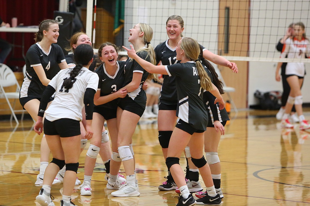 ACH players swarm around junior Emma Whitaker (3) after she aced on her final three serves of the Warriors’ 3-1 win over Odessa Thursday night.