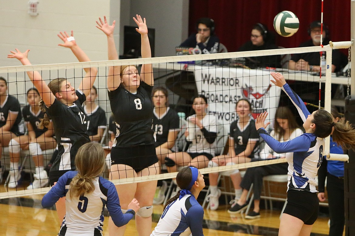 Warrior seniors Kady Murray (8) and Mariah McWalter (12) jump up to attempt a block against Curlew.