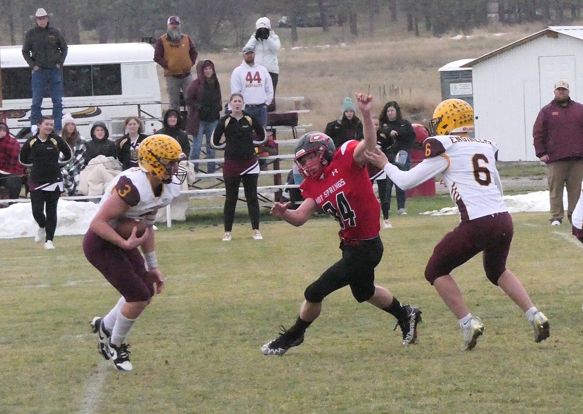 Hot Springs junior linebacker David Chapman gets by Harlowton blocker Gabe Dill (6) in pursuit of Engineers quarterback Bergen Mysse Saturday afternoon in Hot Springs during a state Six-player football quarterfinal.  (Chuck Bandel/VP-MI)