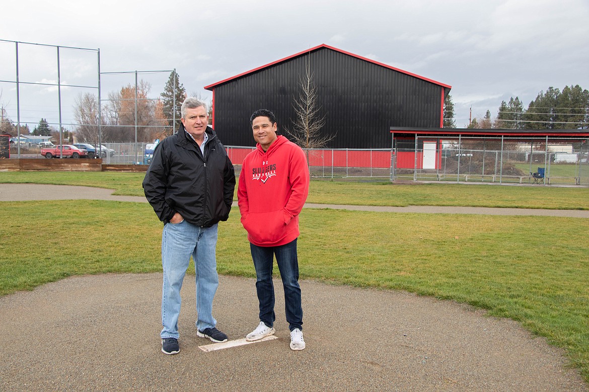 Frank Garner and Chris Gillette are board members for ABS Park. The black and red building is the park's new indoor training facility. (Kate Heston/Daily Inter Lake)