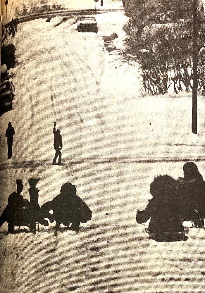 A boy signals all-clear to his sledding friends on the Boyd Avenue hill.