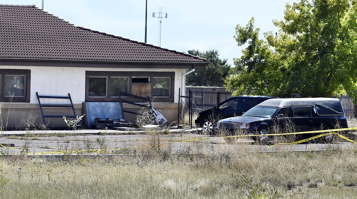 A hearse and debris can be seen at the rear of the Return to Nature Funeral Home in Penrose, Colo., Oct. 5, 2023. A family filed a lawsuit Monday, Oct. 30, against the Colorado funeral home where 189 decaying bodies were found alleging that the owners, a husband and wife, allowed the remains of their loved ones and to “rot” away while they sent families fake ashes. (Jerilee Bennett/The Gazette via AP, File)