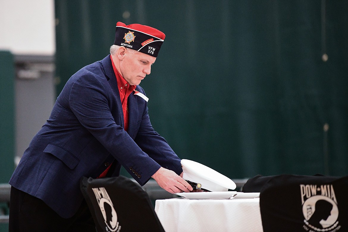 Tom Nugent, Senior Vice Commander with Lion Mountain VFW Post No. 276, places a Marine dress cap at The Missing Man Table during the Veterans Day Community Event at Whitefish High School on Thursday, Nov. 9. The Missing Man Table was dedicated to the 359 servicemen still missing from the Battle of Tarawa, a three-day battle in November 1943 where 1,020 United States servicemembers lives were lost. (Casey Kreider/Daily Inter Lake)