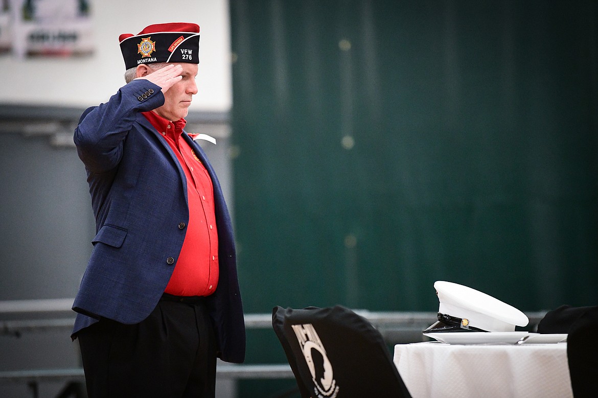 Tom Nugent, Senior Vice Commander with Lion Mountain VFW Post No. 276, salutes after setting a Marine dress cap at The Missing Man Table during the Veterans Day Community Event at Whitefish High School on Thursday, Nov. 9. The Missing Man Table was dedicated to the 359 servicemen still missing from the Battle of Tarawa, a three-day battle in November 1943 where 1,020 United States servicemembers lives were lost. (Casey Kreider/Daily Inter Lake)