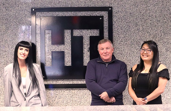 Judd Jones, president of Hagadone Technologies, is joined by Cat Soto, business development manager, left, and Ashley Tangen, director of software development, at the lobby of their front office.