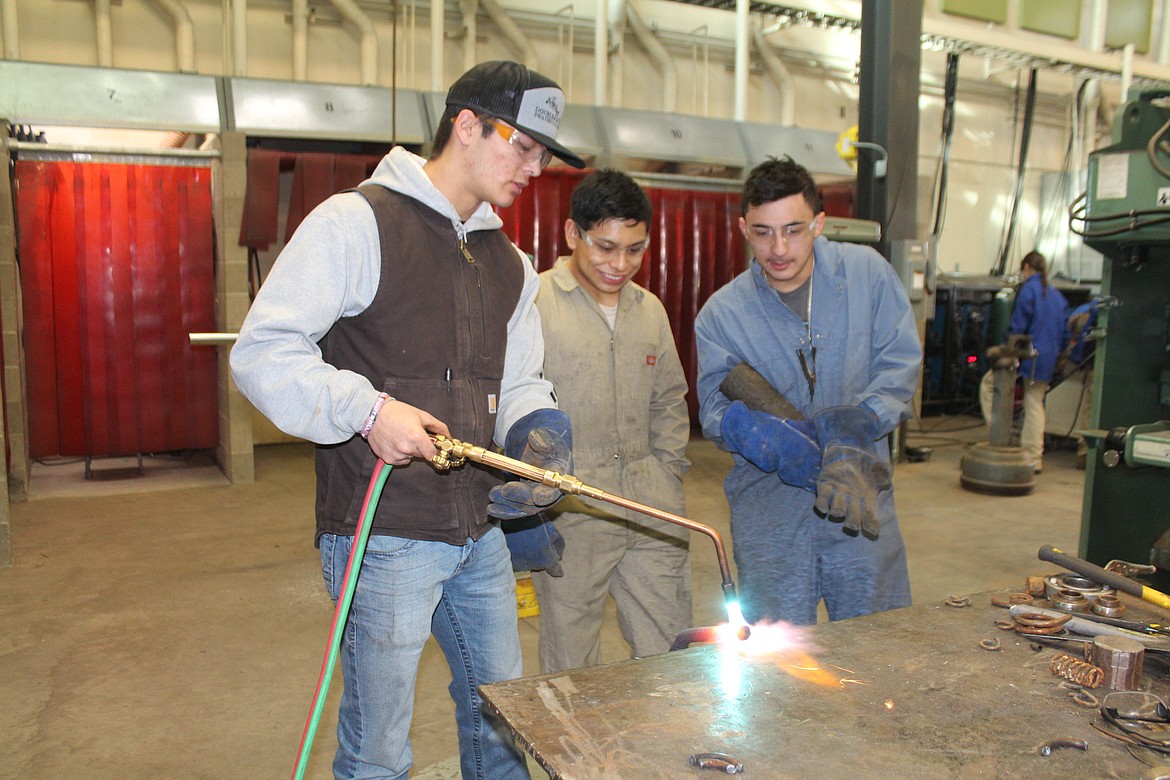 From left, Max Anderson, Uriel Ramos and Israel Baragas work on bending rebar.