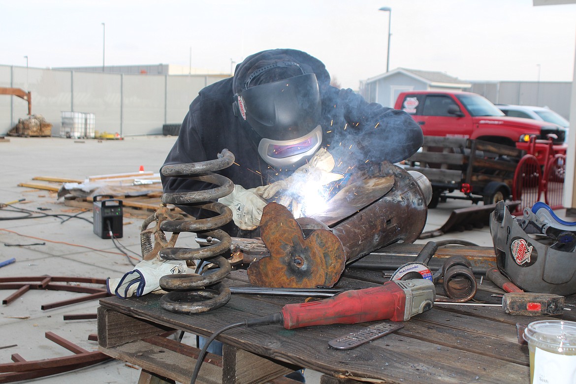 Tyler Hansen of Miner Services works on the submarine the crew built from scrap metal. Miner Services brought a team to the scrap metal art contest just for fun, owner Seth Miner said.