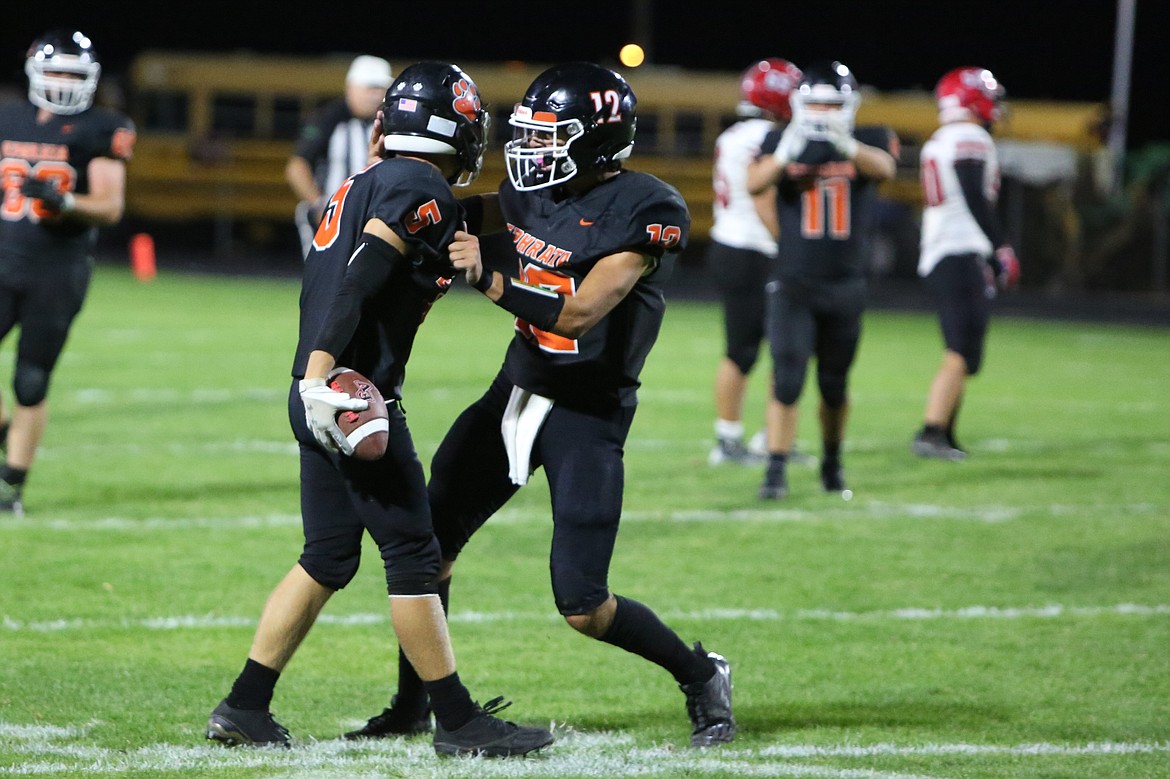 Ephrata senior Walker Fulk, left, and sophomore Brady Hendrick, right, celebrate after Fulk intercepted a pass against East Valley (Yakima).