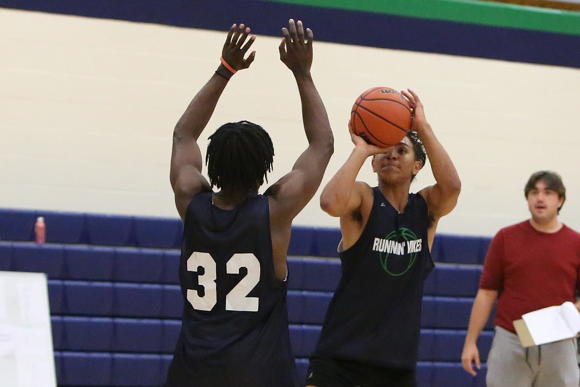 Big Bend freshman Gideon Harris, right, gets ready to take a shot during practice.