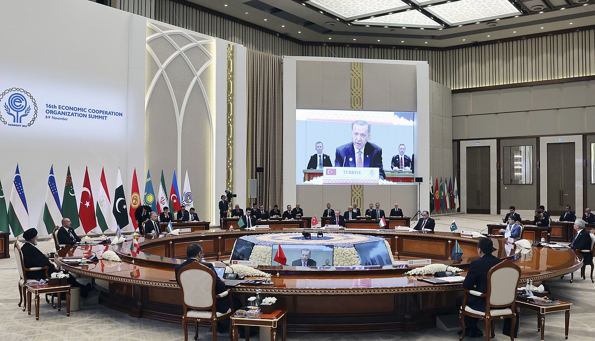 In this handout photo released by Turkish Presidency, Turkey's President Recep Tayyip Erdogan, background center, talks during a meeting of the 10-member Economic Cooperation Organization in Tashkent, Uzbekistan, Thursday, Nov. 9, 2023. (Turkish Presidency via AP)