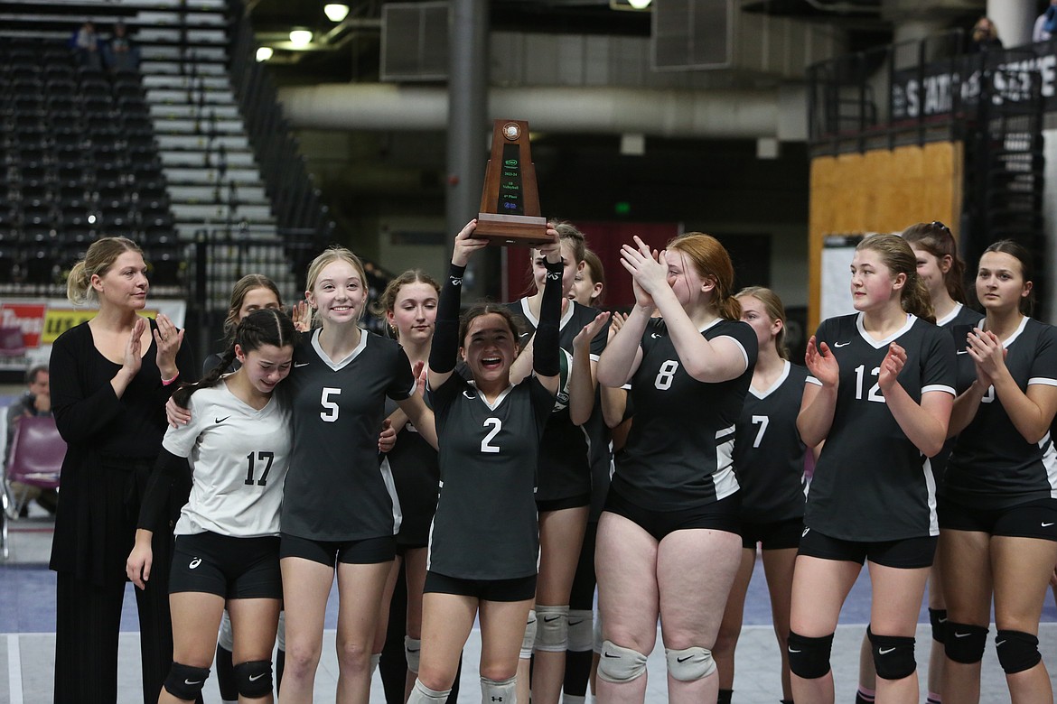 Almira/Coulee-Hartline players smile with the fourth-place trophy at the 1B State Volleyball Tournament.