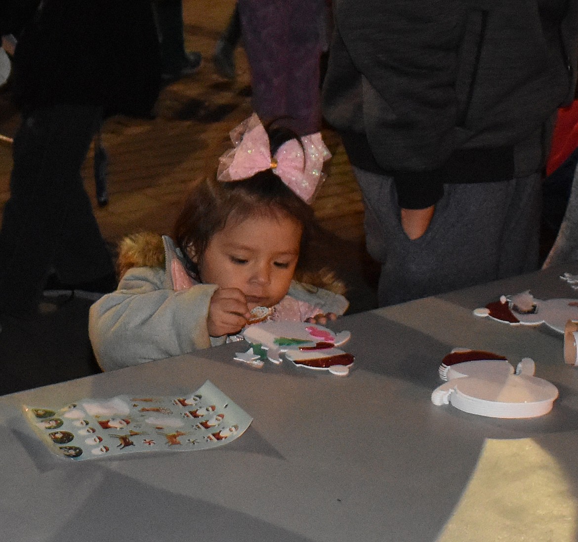 Two-year-old Ivory Ruiz does crafts at a table set up at the Downtown Moses Lake Association’s tree lighting Friday.