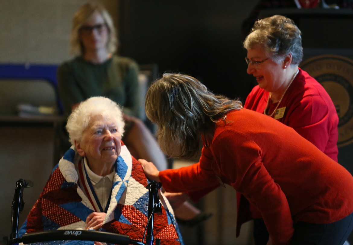 World War II veteran Gladys Stevens looks up at Kathy Whetstone after she receives a Quilt of Valor during a Veterans Day ceremony Friday. Also pictured: Giannine O’Connor.