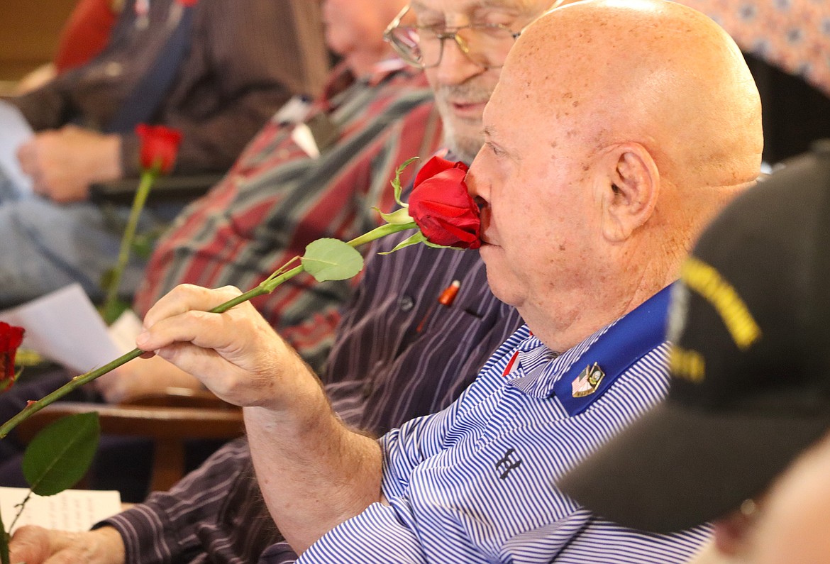 Veteran Richard Holley stops to smell a rose during a ceremony for veterans at Brookdale Coeur d'Alene on Friday.