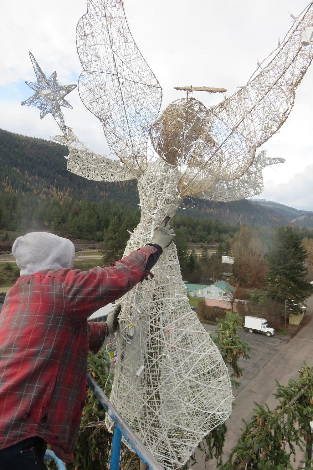 With a 60-foot hoist, volunteers hang Christmas lights on the Mineral County Courthouse and Trail West Bank trees on Saturday. This is all in preparation for the Dec. 2 tree lighting event from 4 to 6 p.m. for a festive beginning of the season. (Photo from Randy Russ)