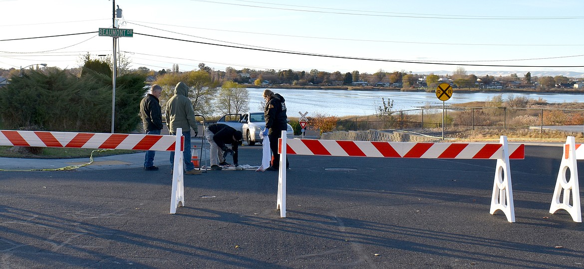 Technicians with the Washington State Patrol crime lab go over the scene of a Sunday shooting Monday afternoon at Linden Street and Beaumont Drive in Moses Lake.