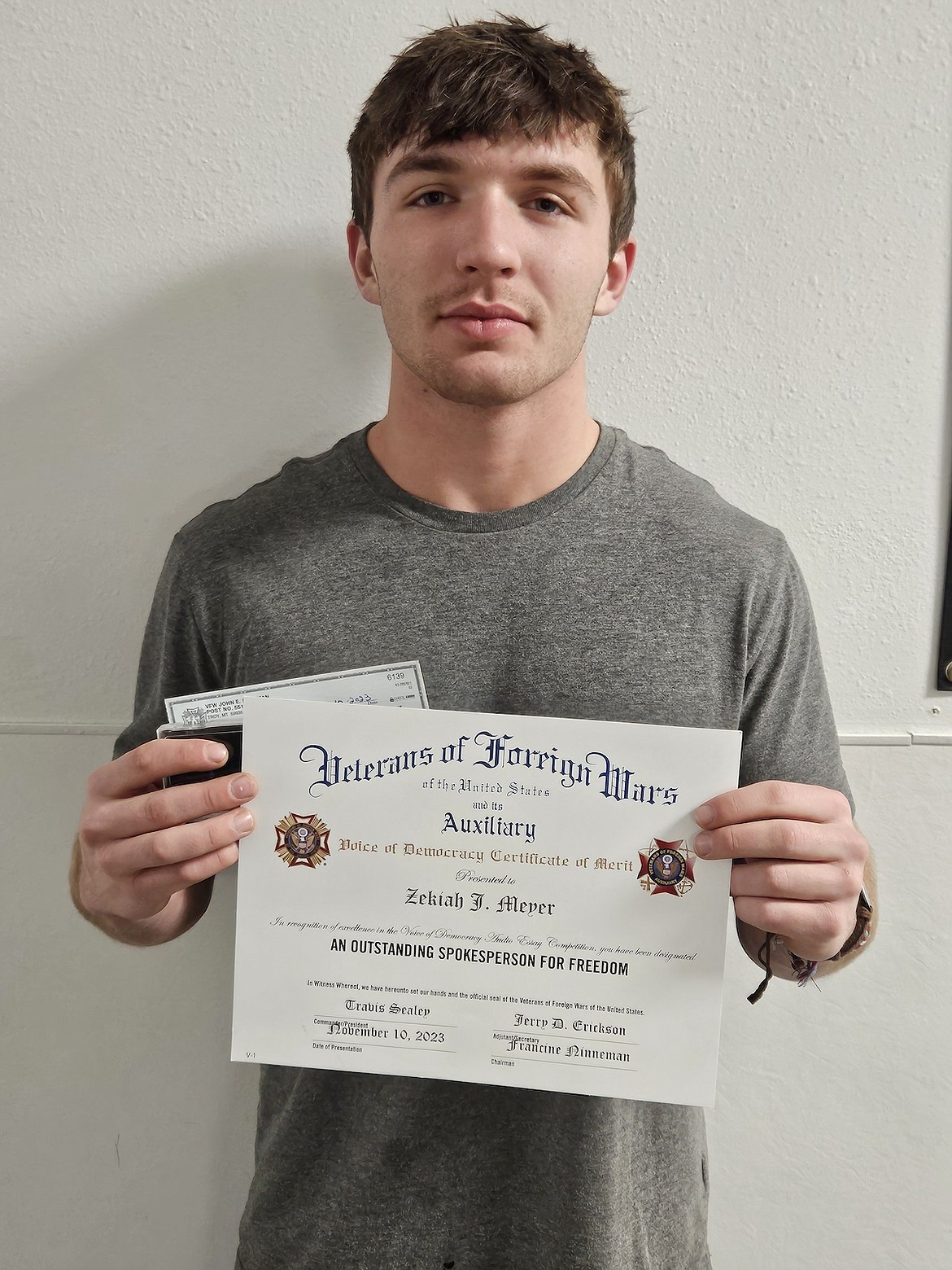 Troy student Zekiah Meyer displays the Voice of Democracy Certificate of Merit and check he received from Troy VFW Post 5514 and its auxiliary. (Photo courtesy Troy Junior Senior High School)