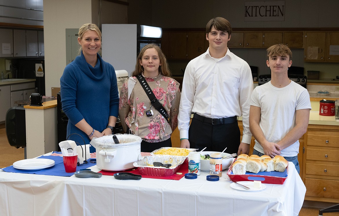 Family and consumer science teacher Charity Jermyn with volunteer student servers Brenden Vanderwall, John Thurston and Hallie Corbin. (Tracy Scott/Valley Press)