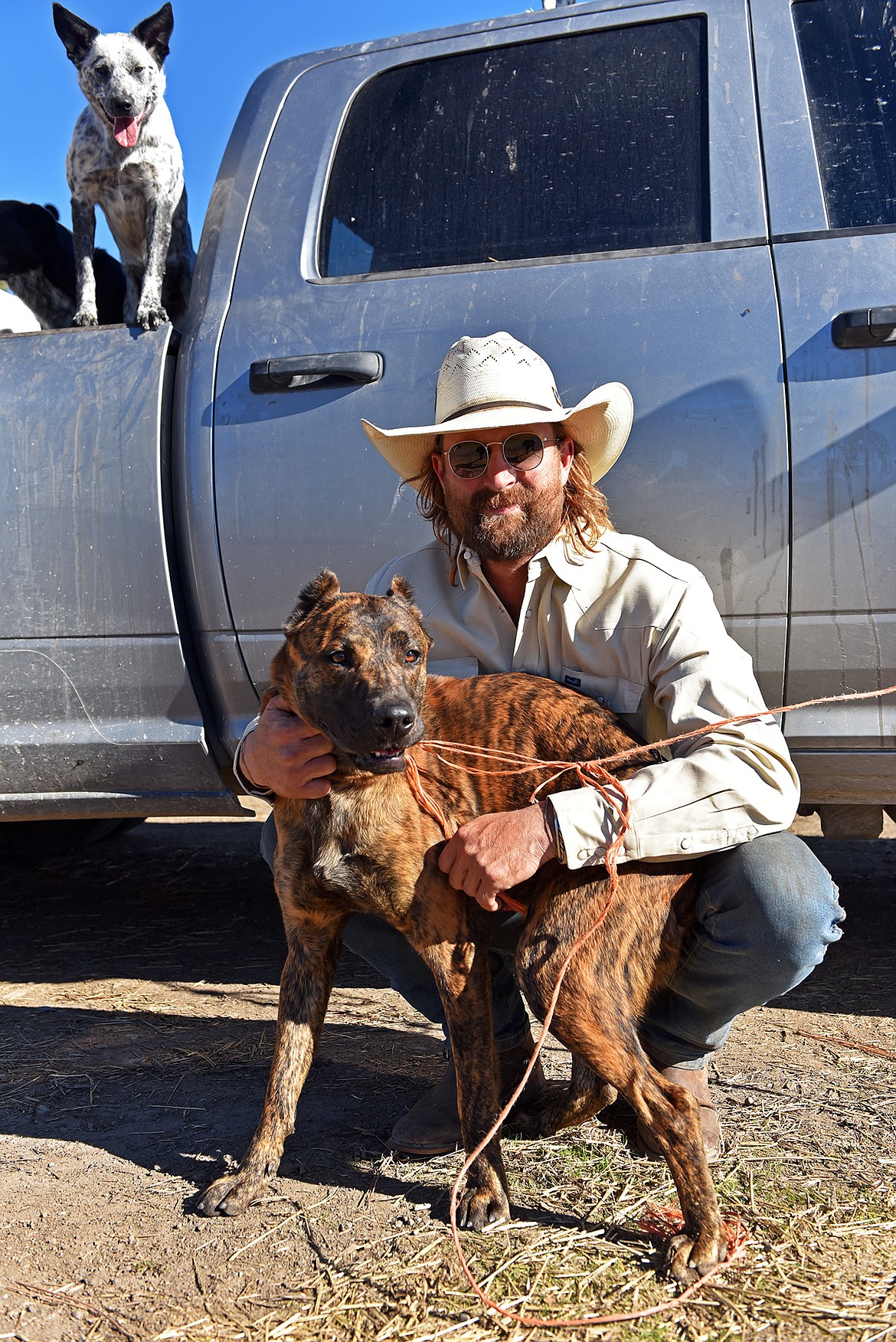 Coach, cowboy and artist Bradley Chance Hays with two of his cattle dogs. (Julie Engler/Whitefish Pilot)