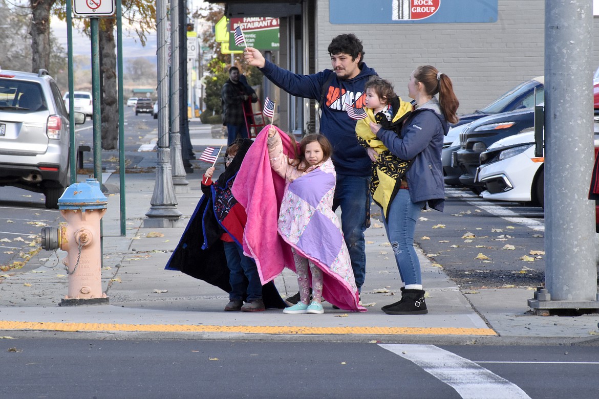 A family cheers on the Veterans Day parade as it winds through downtown Ephrata Saturday.