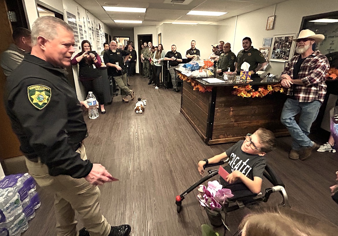 Kootenai County Sheriff Bob Norris talks to Edward Vawter during a farewell party for the 12-year-old on Tuesday.