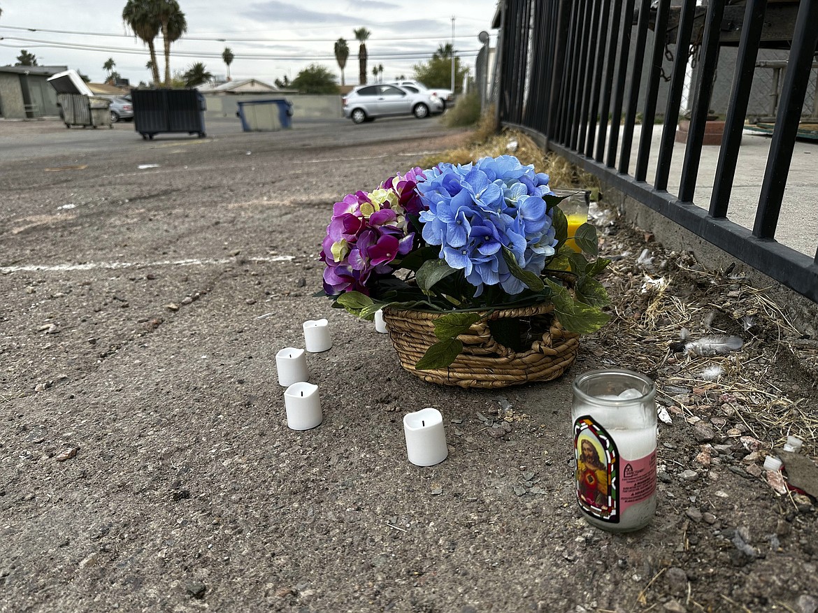 A makeshift memorial for a high school student lines a fence along an alleyway near Rancho High School in eastern Las Vegas on Wednesday, Nov. 15, 2023. Authorities arrested eight teens Tuesday in connection with the beating of Jonathan Lewis Jr., who died a week after a prearranged fight over a pair of headphones and a vape pen. (AP Photo/Rio Yamat)