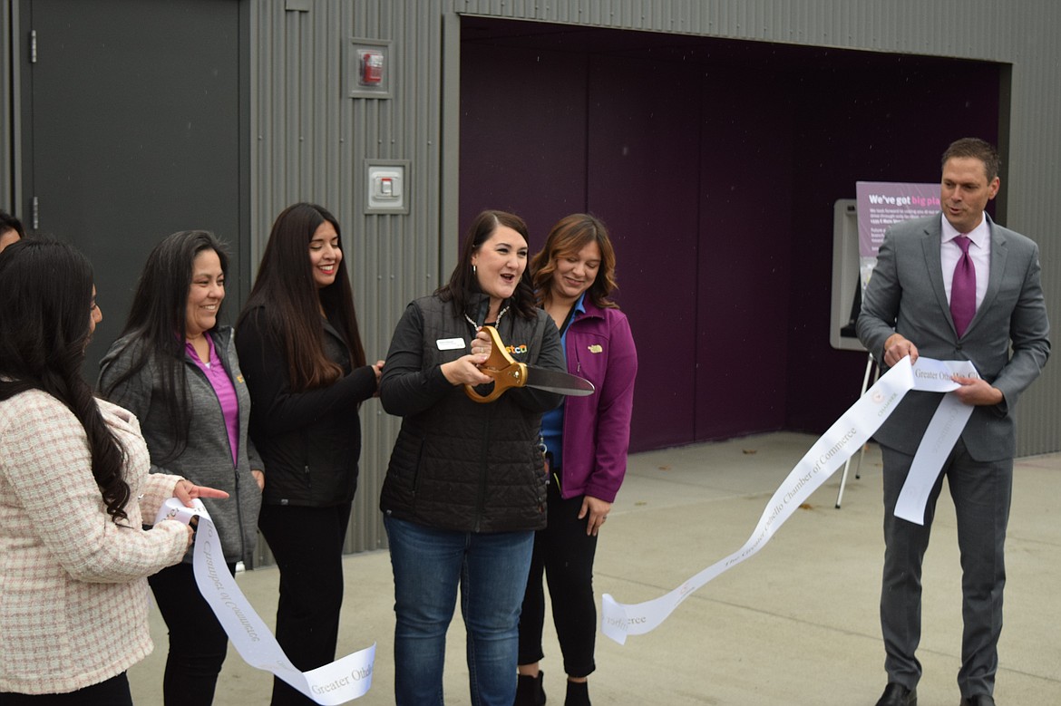 STCU Othello Branch Manager Kerrie Petersen, standing with other STCU staff, cuts the ribbon celebrating the new Othello STCU drive-through location Wednesday at 1333 E. Main St. while STCU President and CEO Ezra Eckhardt, right, and Greater Othello Chamber of Commerce Manager Jackie Wilhelm, left, hold the ribbon.