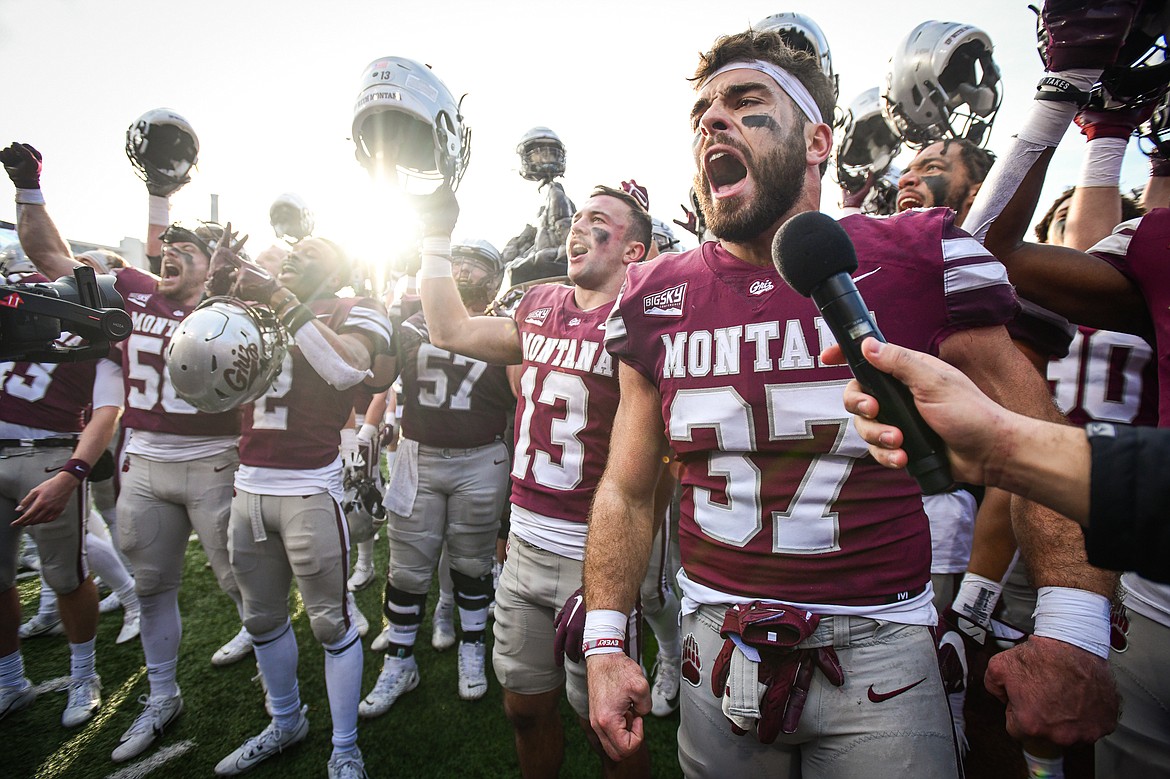 The Grizzlies sing "Up With Montana" while holding the Great Divide Trophy, lead by linebacker Levi Janacaro (37), after a 37-7 victory over Montana State in the 122nd Brawl of the Wild at Washington-Grizzly Stadium on Saturday, Nov. 18. (Casey Kreider/Daily Inter Lake)