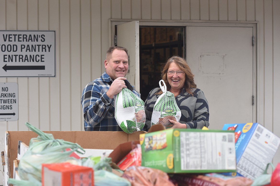 Cinnamon Davis-Hall, right, shows off turkeys donated to the Northwest Montana Veterans Food Pantry alongside Ryan Keeler, quartermaster of the Glacier Park Post 2252 of the Veterans of Foreign Wars, on Monday, Nov. 20, 2023. The pantry distributes Thanksgiving fixings to Flathead Valley veterans and their families. (Derrick Perkins/Daily Inter Lake)