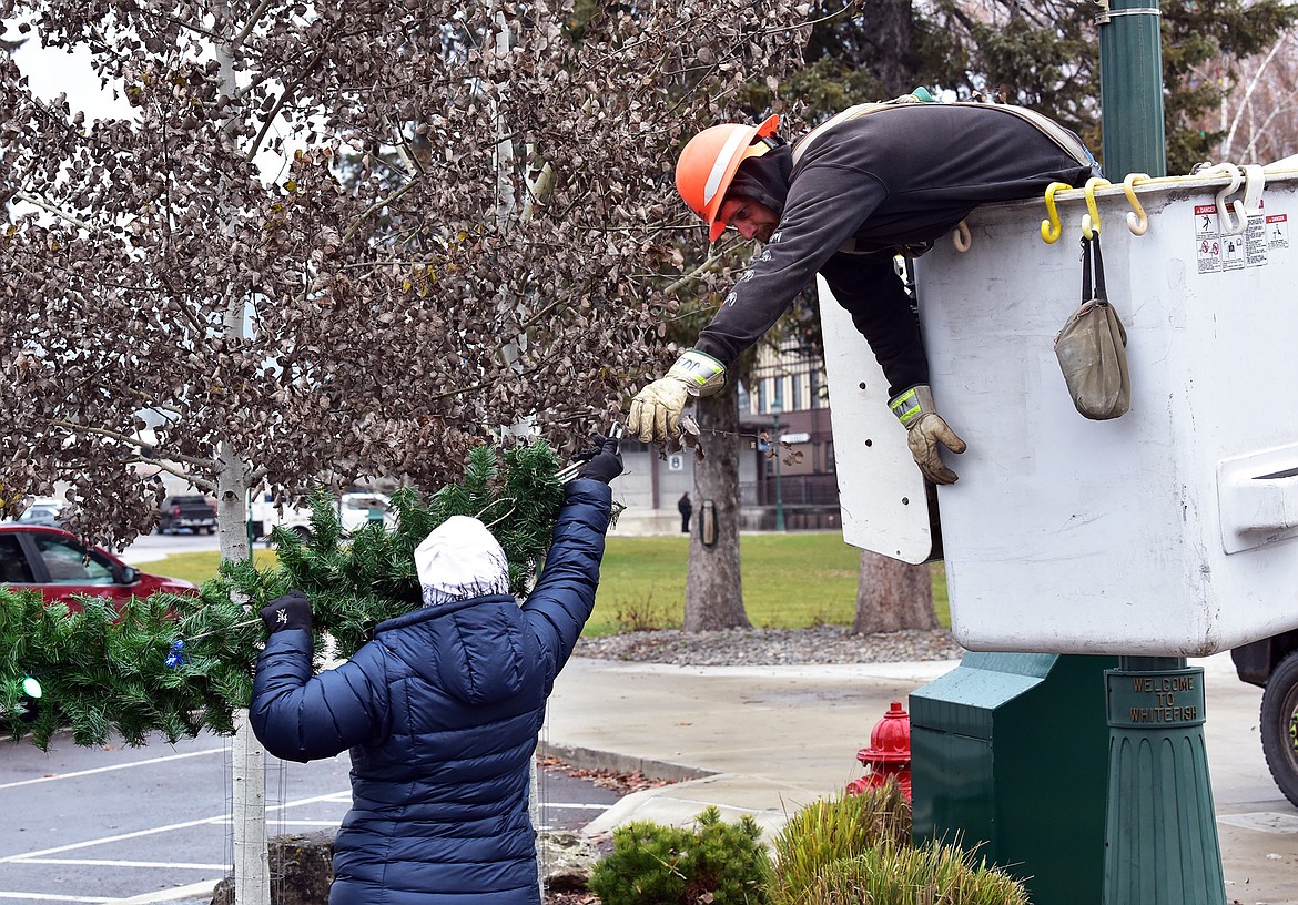 Flathead Electric Cooperative and several residents volunteered to put up Whitefish's winter decorations on Sunday. (Julie Engler/Whitefish Pilot)