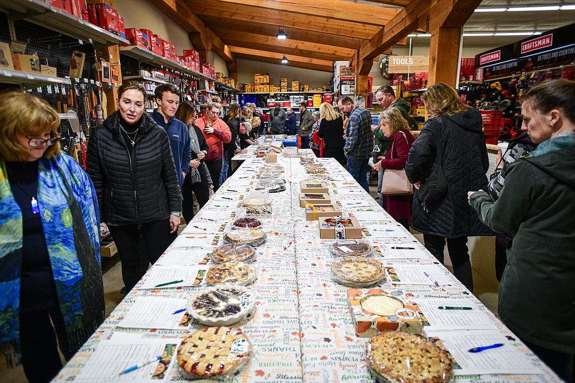 Attendees bid on pies during the silent auction at the annual Light Up Evergreen & Pie Auction at Glacier Ace Hardware on Tuesday, Nov. 21. (Casey Kreider/Daily Inter Lake)