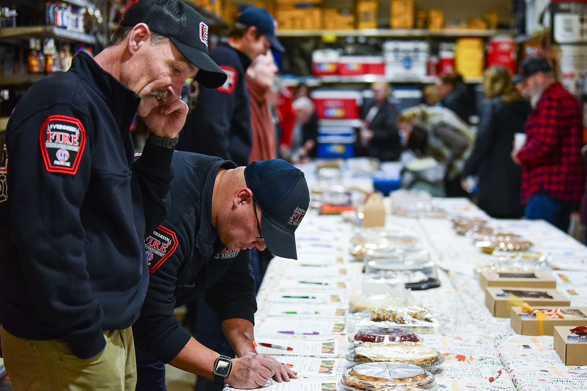 Attendees bid on pies during the silent auction at the annual Light Up Evergreen & Pie Auction at Glacier Ace Hardware on Tuesday, Nov. 21. (Casey Kreider/Daily Inter Lake)