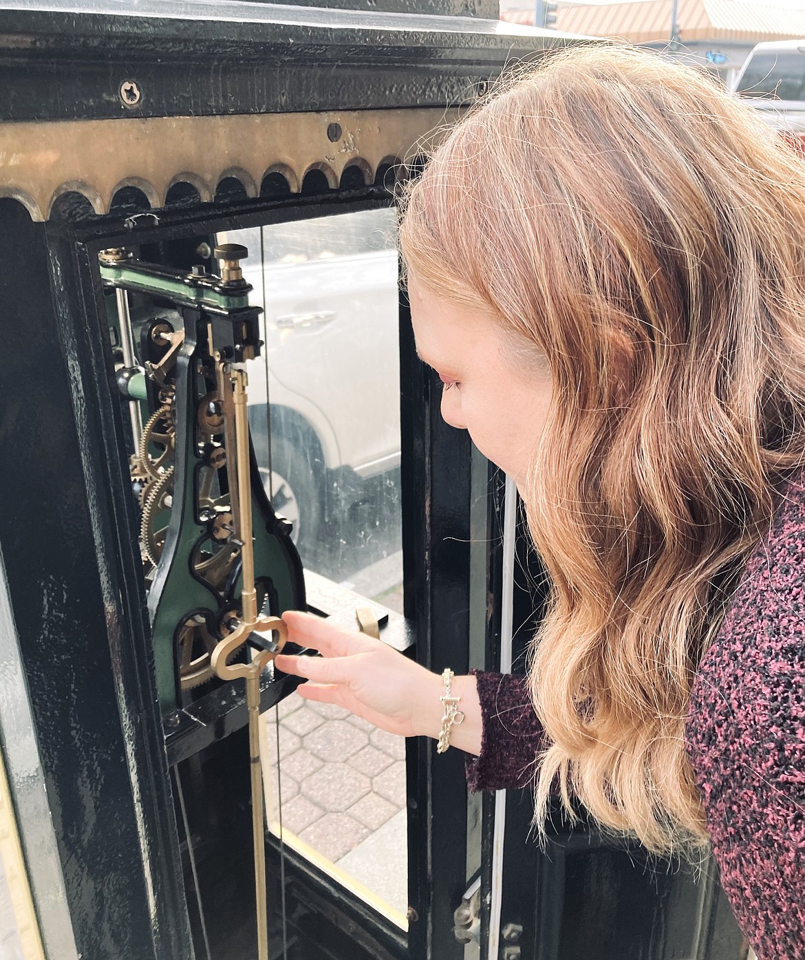 Owner Jane Clark adjusts the street clock’s mechanism.