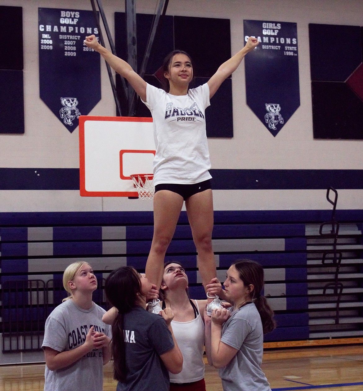 Badger cheerleaders practice stunting.