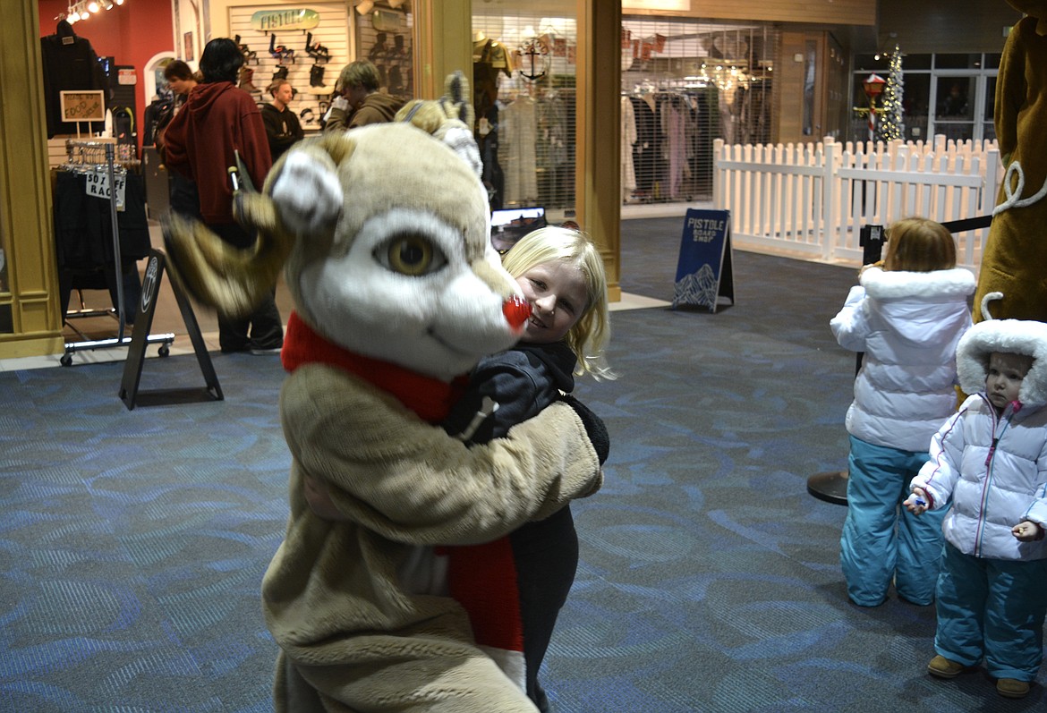 Thorben Willie got in close for a hug with Rudolph the Red-Nosed Reindeer at the Resort Shops before taking a Journey to the North Pole with his family Tuesday evening.