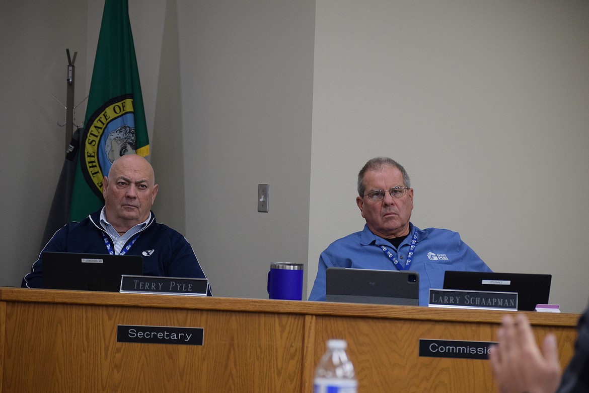 Grant County PUD commissioners Terry Pyle, left, and Larry Schaapman, right, listen to a presentation on 2024 power rates.