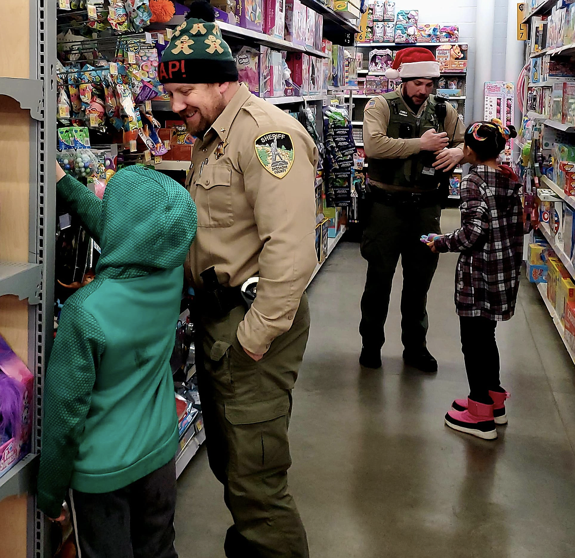 A photo from the 2022 Shop with a Cop event shows Undersheriff Lance Stutzke and Deputy Jake End with their shopping partners.