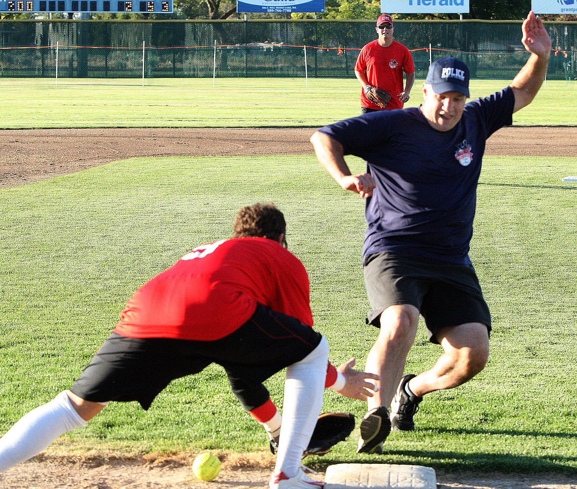 Moses Lake Police Department runner Kevin Fuhr beats the throw into third base as fire department third baseman Mark Graham tries to make the play during the 2016 Battle of the Badge softball game at Larson Playfield. The police and fire departments raised an estimated $3,000 for the Boys & Girls Club of the Columbia Basin.