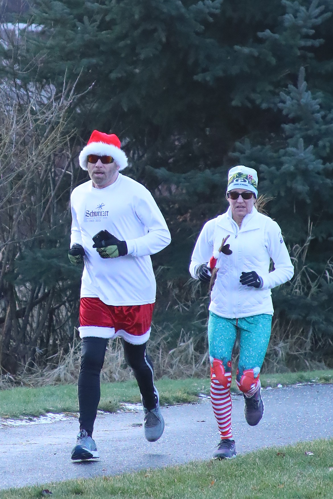 A pair of runners run along the trail surrounding the Travers-Great Northern park complex during Thursday's Turkey Trot fun run. The annual event benefits the Bonner Community Food Bank.