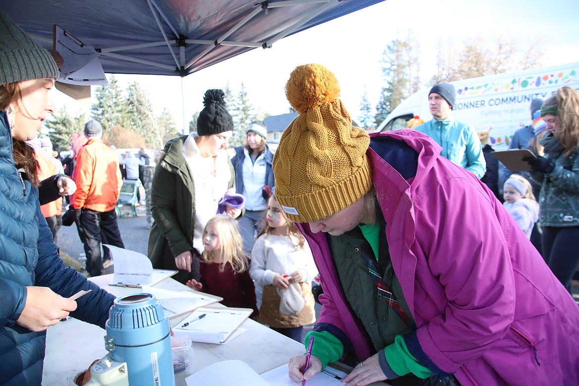 A Turkey Trot participant signs to take part in the annual event. Held on Thanksgiving Day, the event benefits the Bonner Community Food Bank.