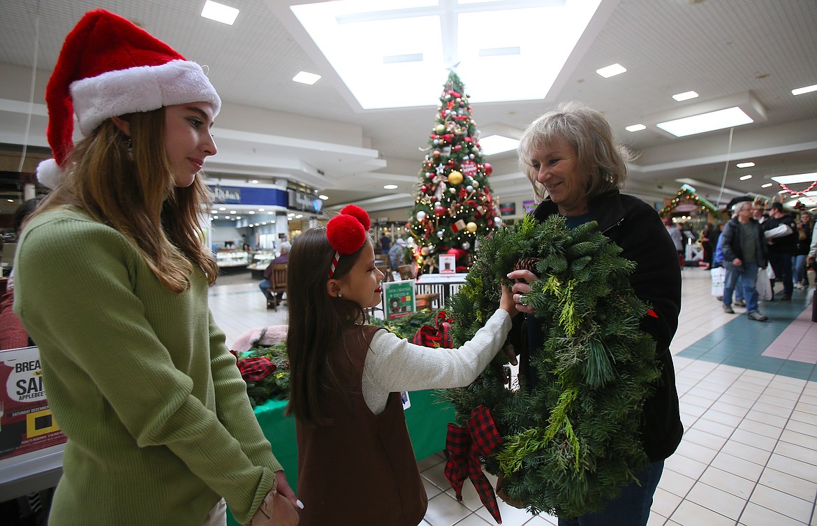 Chrisdee Imthurn buys a fresh wreath from Annalisa McCormick, 7, and Ava Newkirk, 11, who worked to raise travel funds for Girl Scout Troop 4923 during Black Friday at the Silver Lake Mall. “It's so easy to buy online, but you want to support the local community,” said Imthurn, of Hauser.
