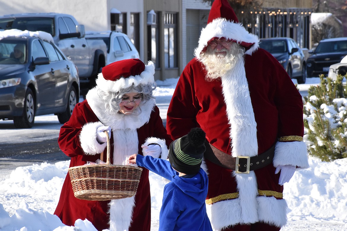 Mrs. Santa and Santa distribute candy canes to children during the 2022 Winterfest celebration in Soap Lake. Winterfest 2023 is Saturday.