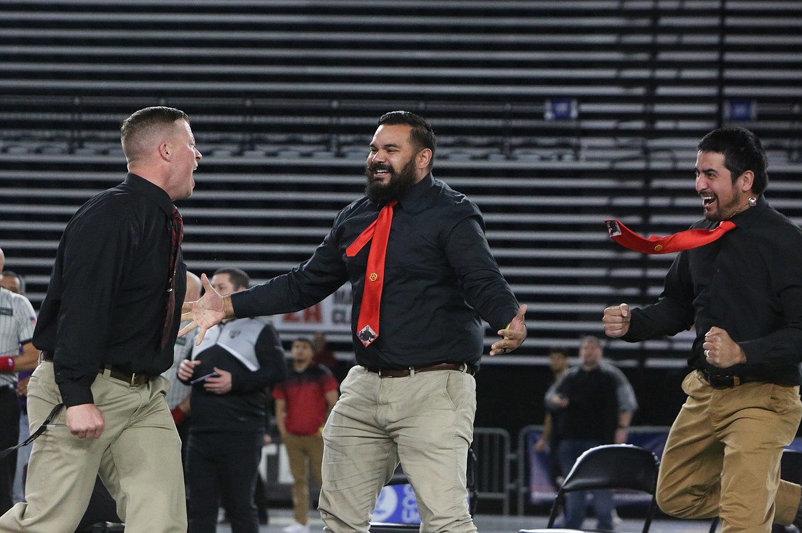 Othello coaches celebrate after graduate Terrill Freeman won a state title last year. Head Coach Rudy Ochoa II, center, credited his fellow coaches on the staff for helping prepare the Huskie wrestlers for this upcoming season.