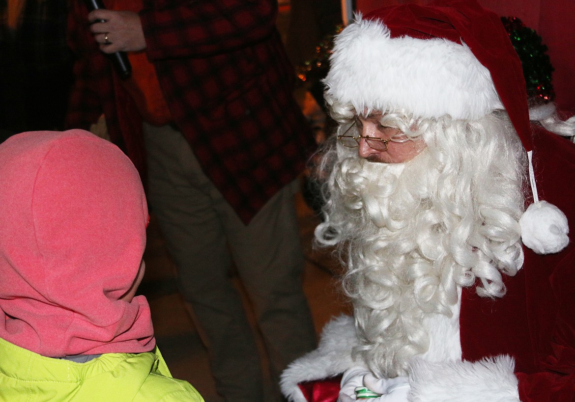 Santa Claus listens as a young fan shares what they would like for Christmas as the Jolly Old Elf came to Sandpoint on Friday for the town's annual tree lighting ceremony.