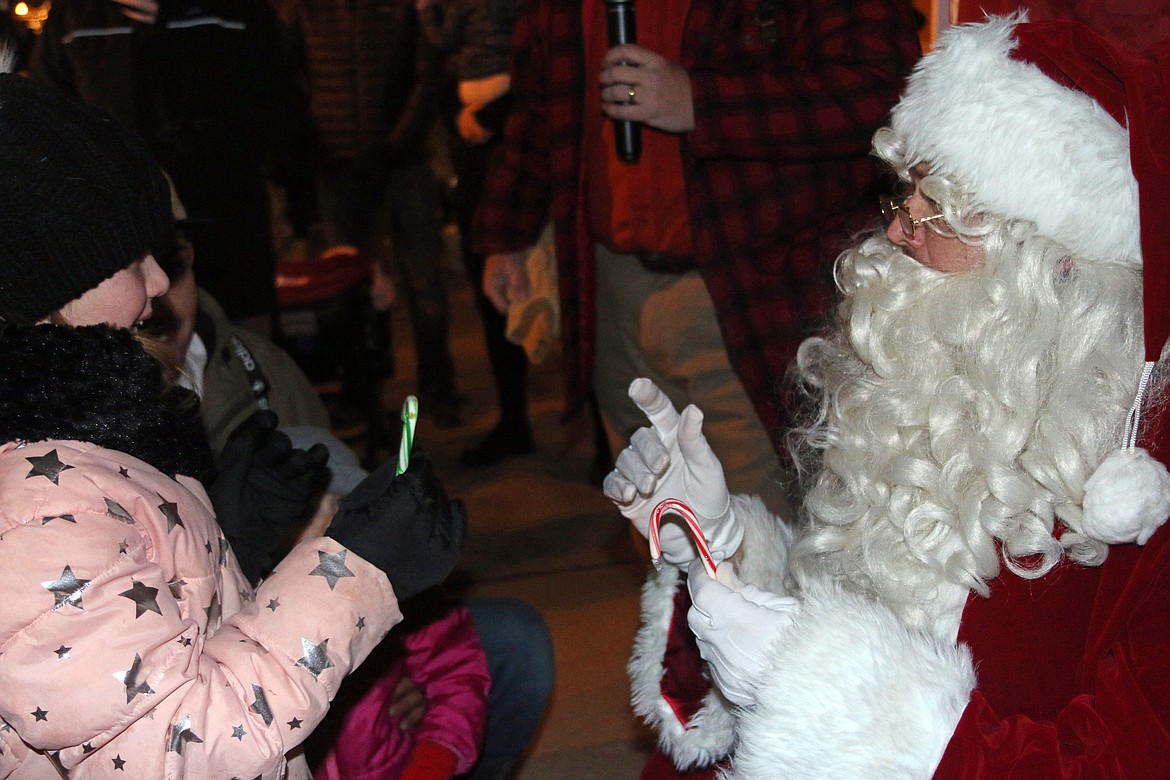 Santa Claus listens as a young fan says hello as he visited Sandpoint during the town's annual tree lighting ceremony Friday at Jeff Jones Town Square.